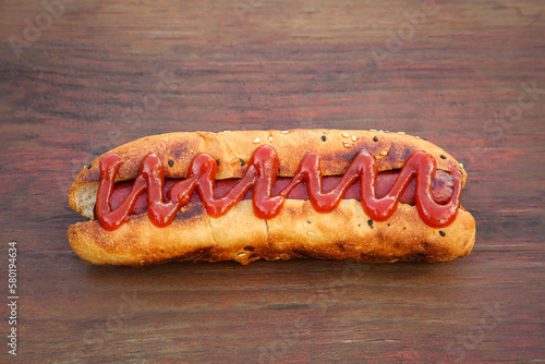 Fresh tasty hot dog with ketchup on wooden table