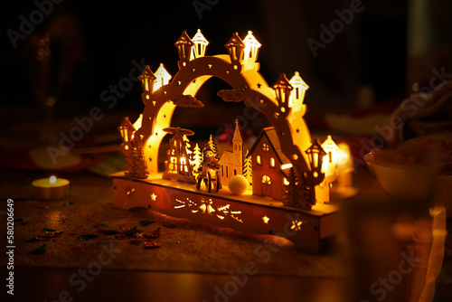 Schwibbogen (Christmas arch) as decoration on a table. German tradition from the Erzgebirge (Ore Mountains). The illuminated object makes a cozy atmosphere during Advent time.