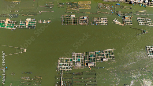 Fish farm on the river and a village with fishermen. Hinigaran River. Negros, Philippines photo