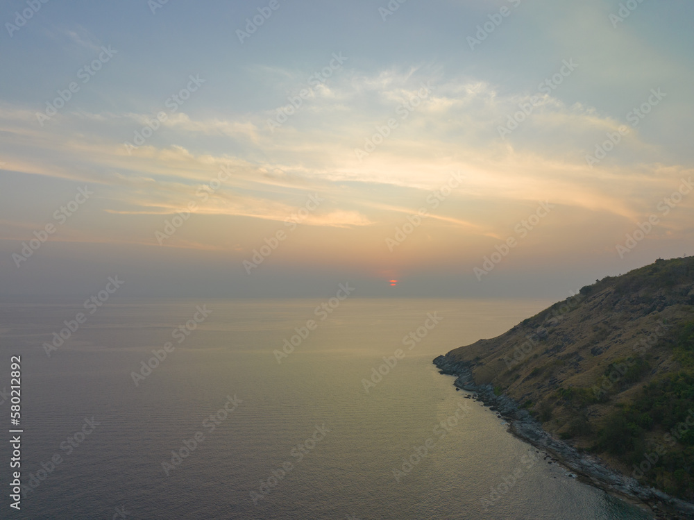 aerial view the sun going down in colorful sky impact on ocean surface.The beauty of the cliff fits perfectly with the charming nature in beautiful sunset..cloud scape background