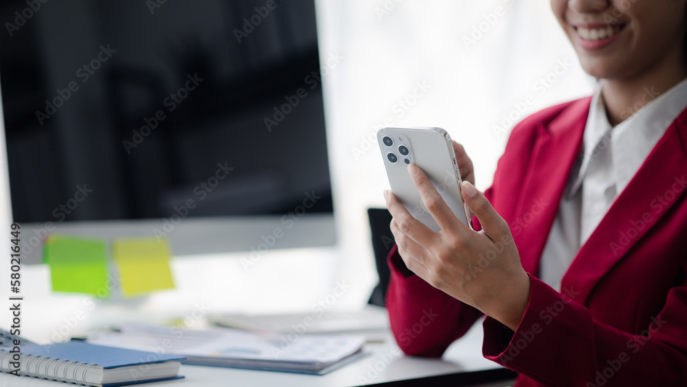 Fototapeta premium Businesswoman holding mobile phone, Asian business woman owner conducts financial management, she set up startup company, modern female leader. Business woman leader concept.