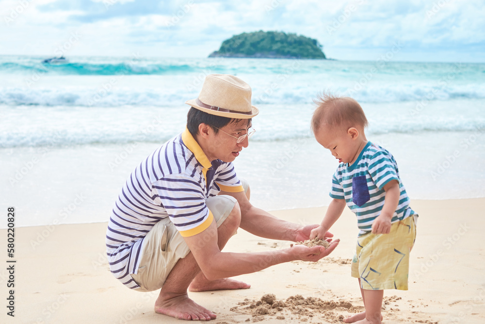 Cute little Asian toddler baby boy child play with dad on white sand beach. Family travel, summer beach vacation with children, Kid touching sand for the first time ,Sand Sensory Play, Phuket Thailand Cute little Asian toddler baby boy child play with dad on white sand beach. Family travel, summer beach vacation with children, Kid touching sand for the first time ,Sand Sensory Play, Phuket Thailand