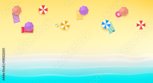 Bright sunny beach with color umbrellas and towels. Top view photo