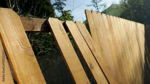 Wood Fence Pickets Lined Up Along an Incomplete Job Site With No Workers