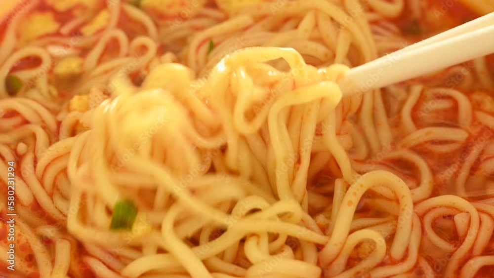 Lifting up instant Dandan noodles with a pair of wooden chopsticks Lifting up instant Dandan noodles with a pair of wooden chopsticks