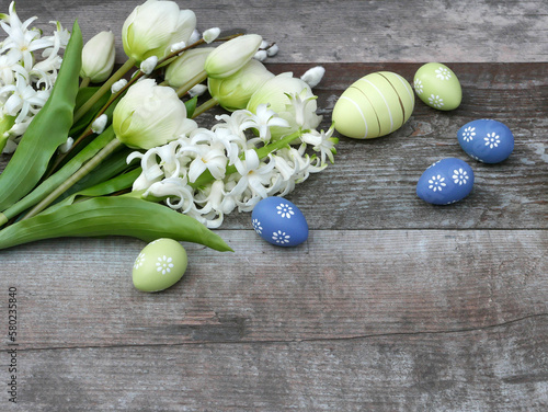 Ostereie rmit Tulpen und Hyazinthen auf einem Holzhintergrund mit Platz für Text. photo