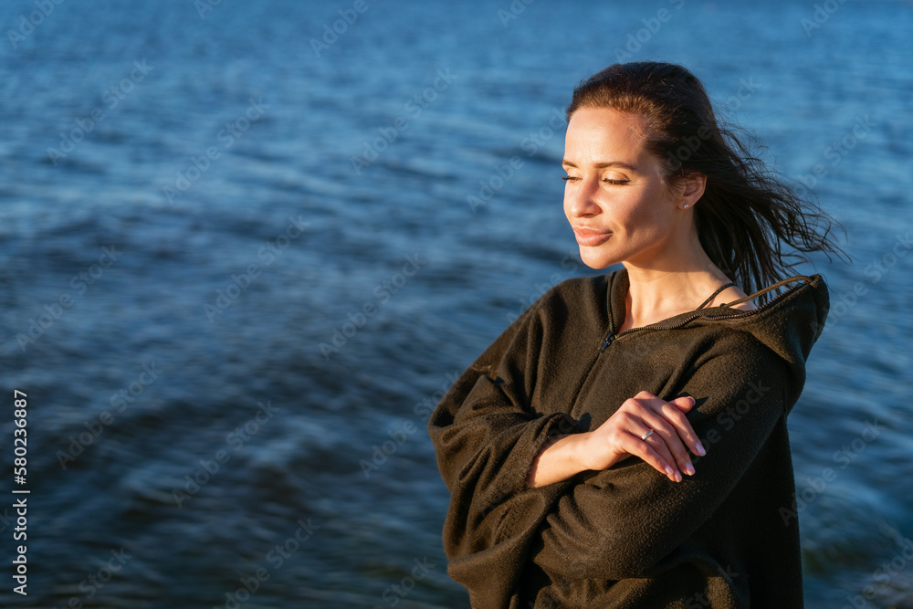 Portrait happy smiling woman on beach. Smiling sensual brunette posing on a beautiful wild beach wearing a brown poncho. Portrait happy smiling woman on beach. Smiling sensual brunette posing on a beautiful wild beach wearing a brown poncho.