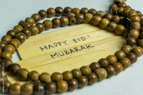 Islamic quotes. Eid Mubarak words written on wooden stick.