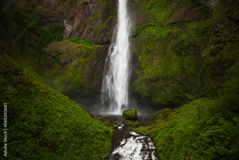 Scenic view of Multnomah Falls on rock formations in forest Scenic view of Multnomah Falls on rock formations in forest