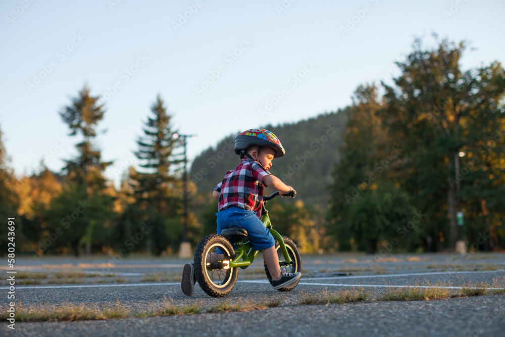 Full length of boy wearing bicycle helmet while cycling at park Full length of boy wearing bicycle helmet while cycling at park
