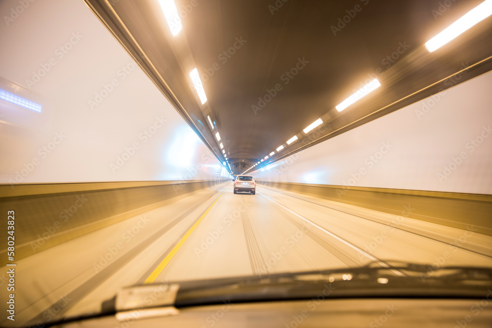Car moving in illuminated tunnel seen though windshield Car moving in illuminated tunnel seen though windshield