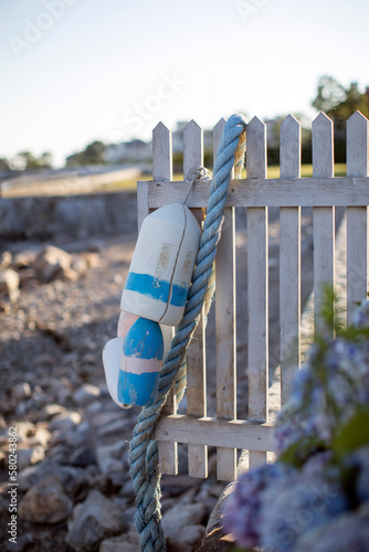 Buoy hanging on wooden fence photo