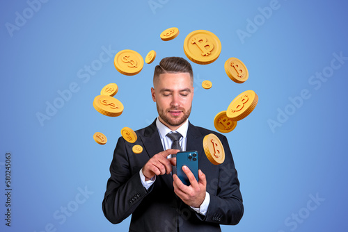 Man with smartphone, bitcoin and dollar coins photo