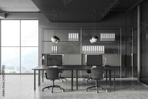 Grey business interior with pc computer and shelf with panoramic window