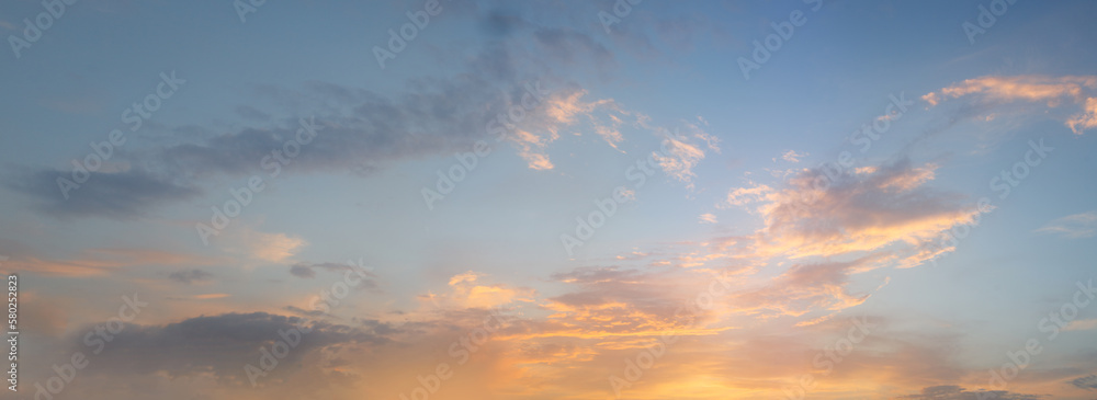 Panorama of evening sky with blue background, white and orange clouds
