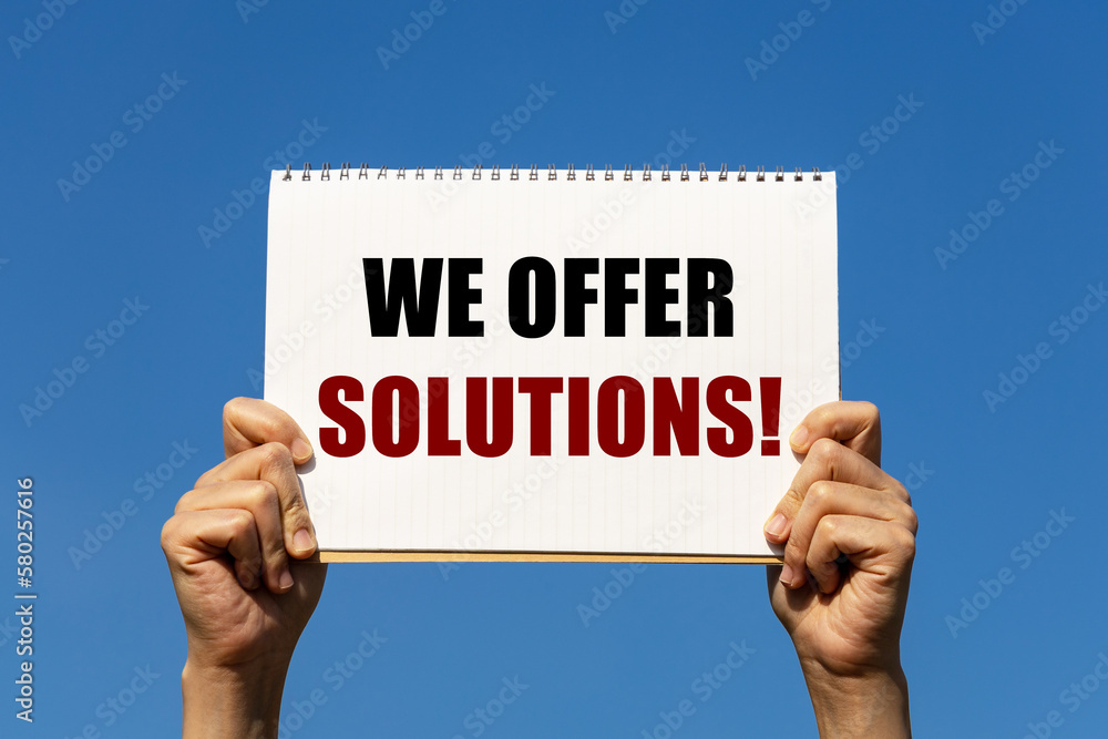 We offer solutions text on notebook paper held by 2 hands with isolated blue sky background. This message can be used as business concept about offering solutions. We offer solutions text on notebook paper held by 2 hands with isolated blue sky background. This message can be used as business concept about offering solutions.