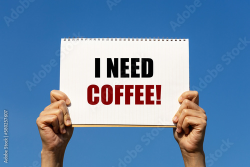 I need coffee text on notebook paper held by 2 hands with isolated blue sky background Fototapet
