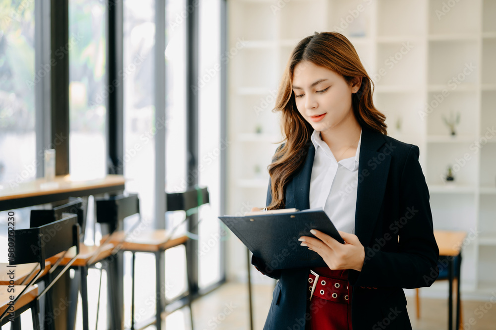 Confident business expert attractive smiling young woman holding digital tablet on desk in creative office. Confident business expert attractive smiling young woman holding digital tablet on desk in creative office.
