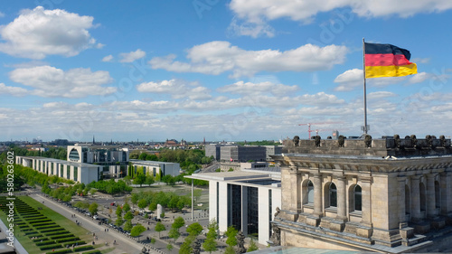 The German flag waives on the top of the Parliament building (Reichstag), aerial view of the Square of the Republic and the chancellor's office building photo