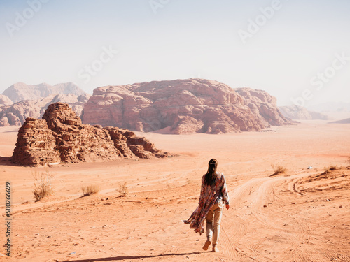 Stylish woman and the sights of the Wadi Rum desert in Jordan. Clear  sunny day. Vacation and travel concept