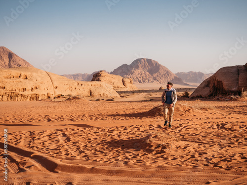 Stylish man and the sights of the Wadi Rum desert in Jordan. Clear, sunny day. Vacation and travel concept © Svetlana