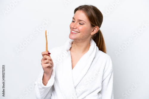 Young caucasian woman brushing teeth isolated on white background with happy expression