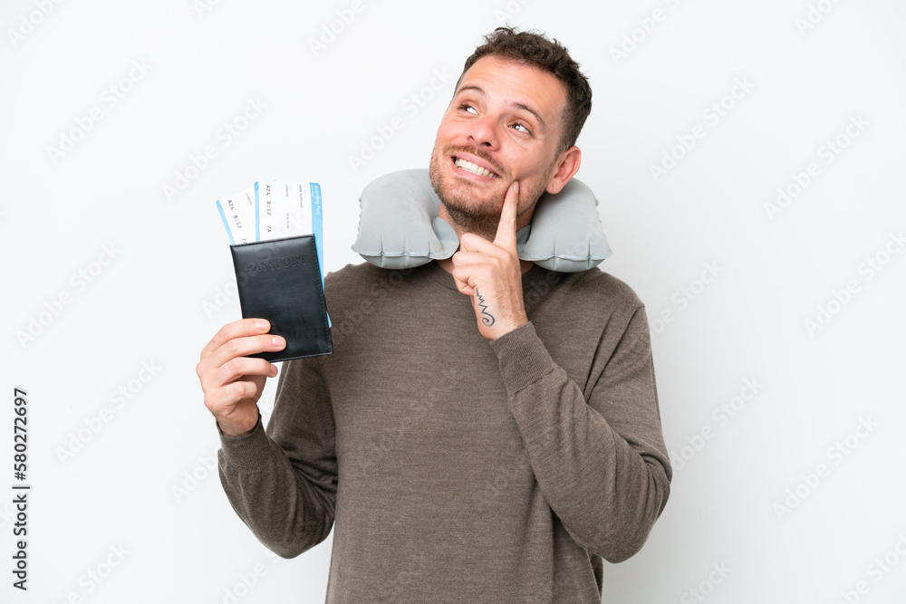 Young caucasian man holding a passport isolated on white background thinking an idea while looking up Young caucasian man holding a passport isolated on white background thinking an idea while looking up