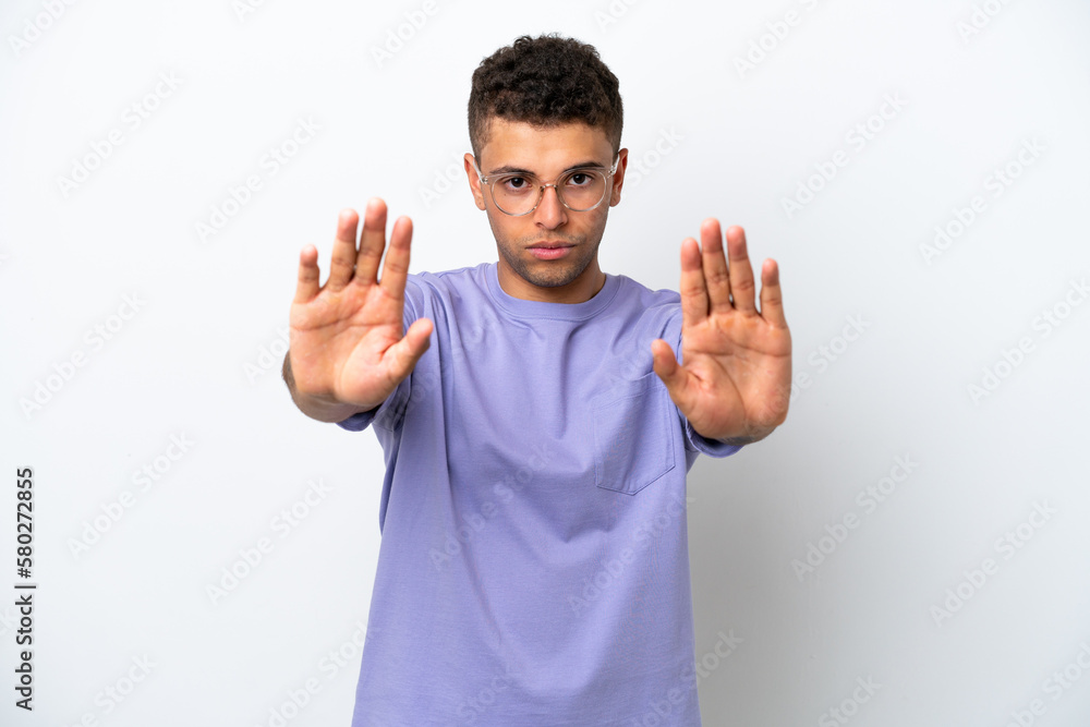 Young caucasian Brazilian man isolated on white background making stop gesture and disappointed Young caucasian Brazilian man isolated on white background making stop gesture and disappointed