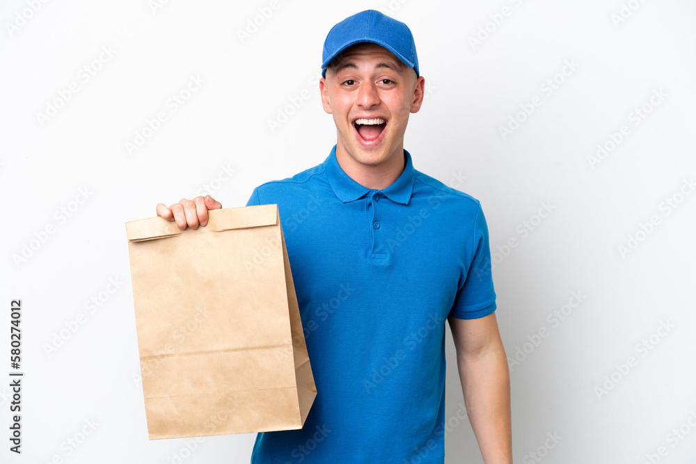 Young Brazilian man taking a bag of takeaway food isolated on white background with surprise facial expression Young Brazilian man taking a bag of takeaway food isolated on white background with surprise facial expression