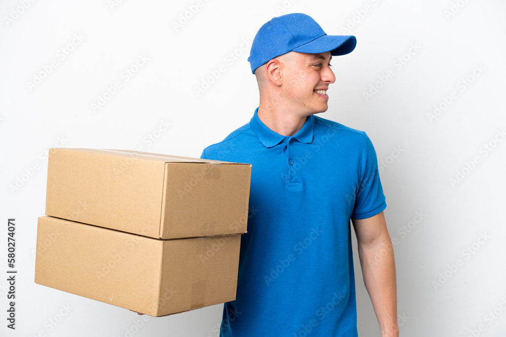 Young delivery Brazilian man isolated ops white background looking side Young delivery Brazilian man isolated ops white background looking side