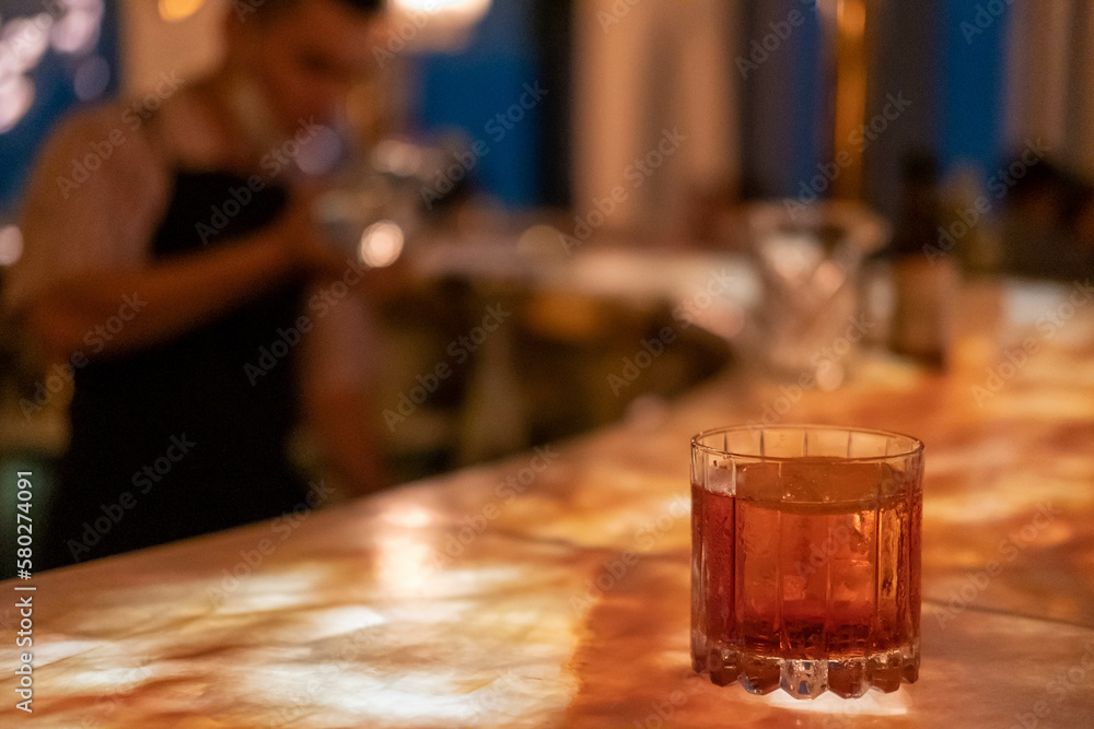 A glass of cocktail on illuminated counter bar A glass of cocktail on illuminated counter bar
