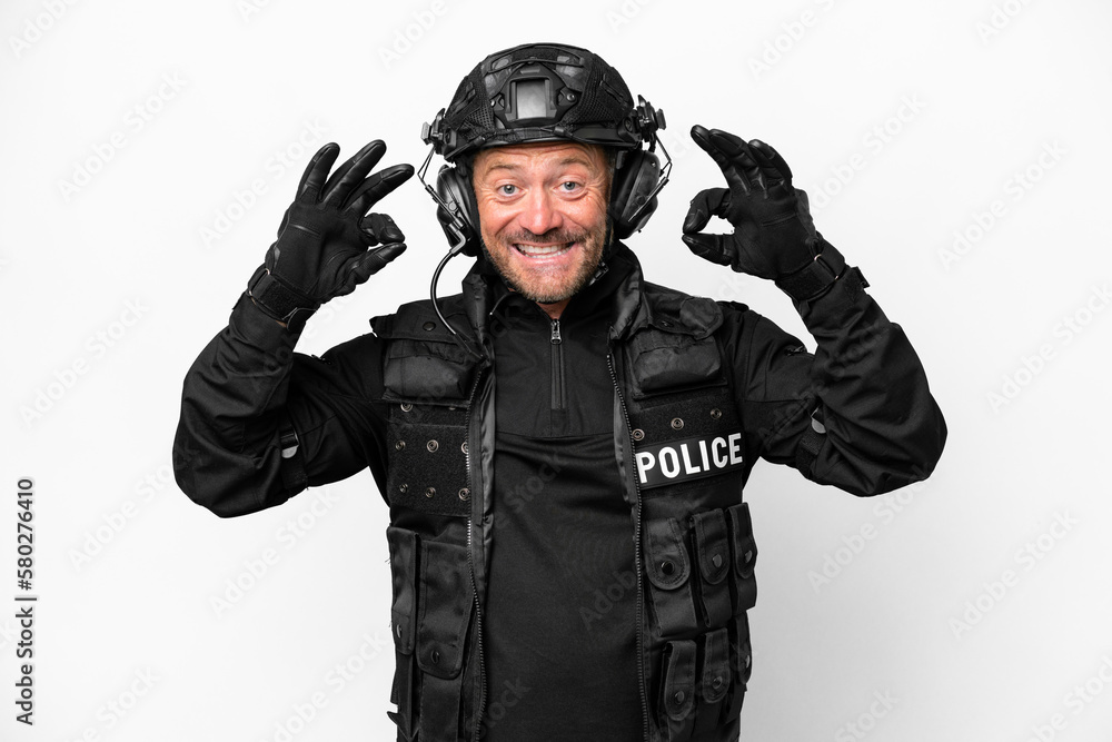 Middle age SWAT man isolated on white background showing an ok sign with fingers Middle age SWAT man isolated on white background showing an ok sign with fingers