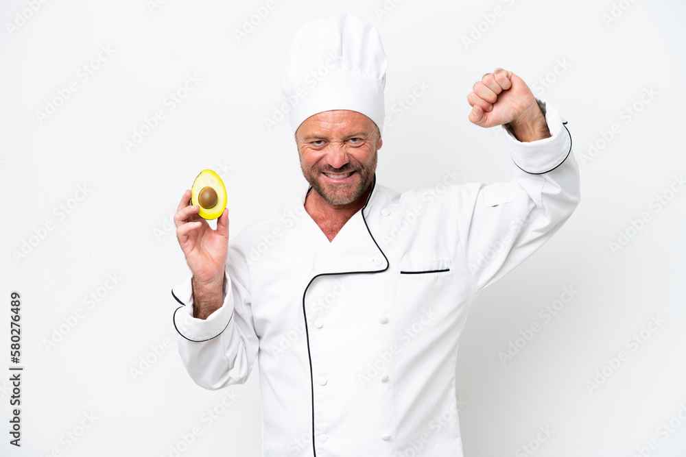 Chef man holding an avocado isolated on white background doing strong gesture Chef man holding an avocado isolated on white background doing strong gesture