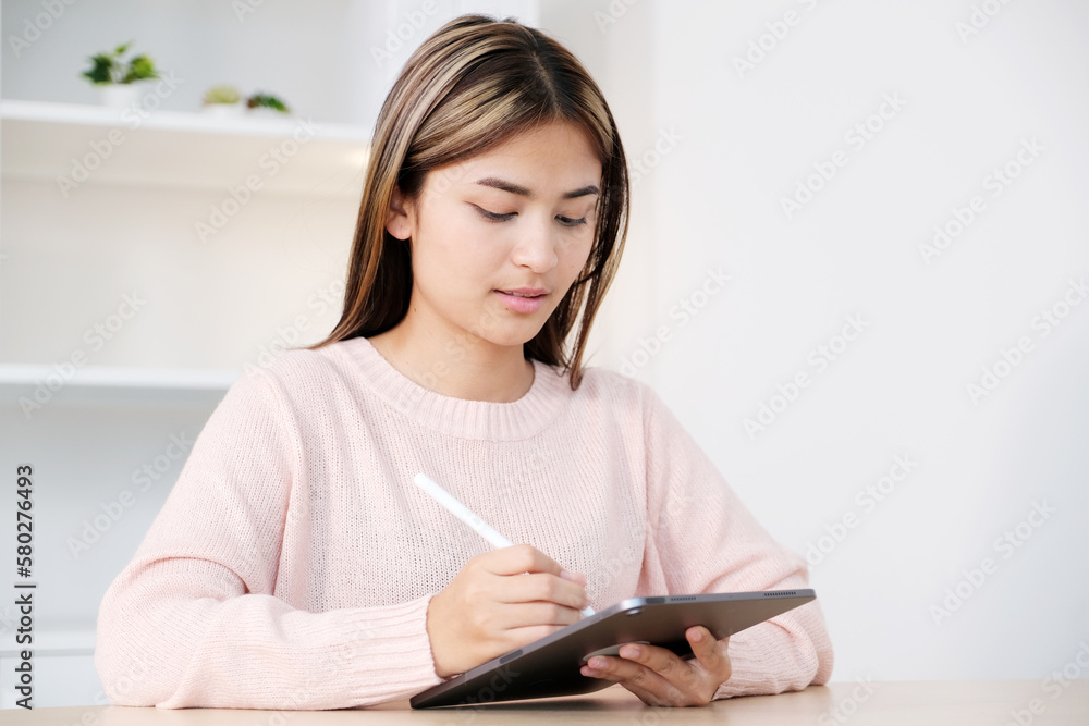Young asian woman using digital tablet at home office Young asian woman using digital tablet at home office