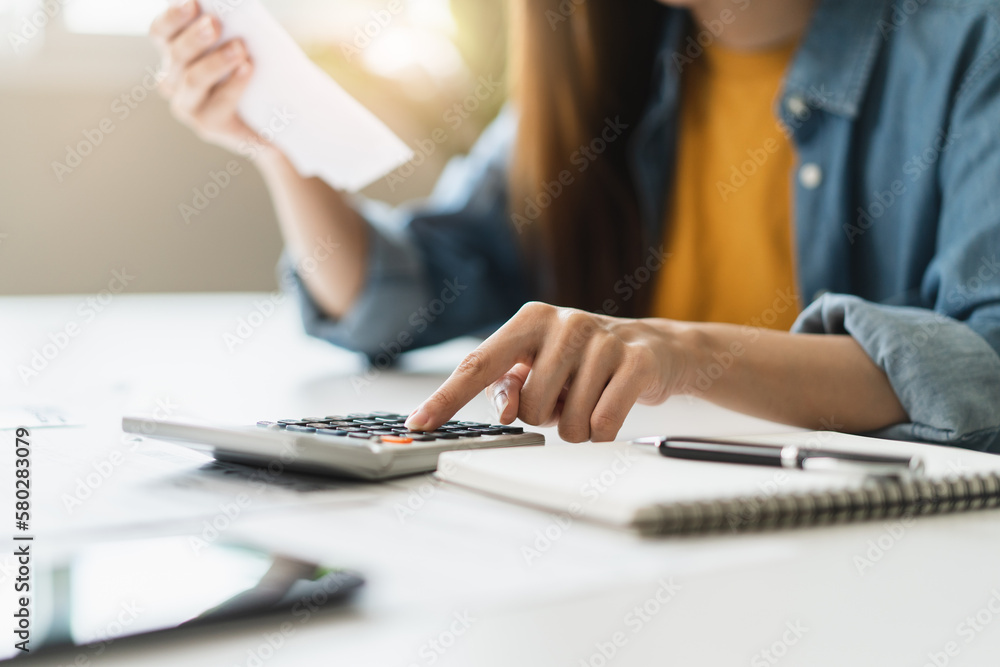 Young Asian women calculating monthly bills Young Asian women calculating monthly bills