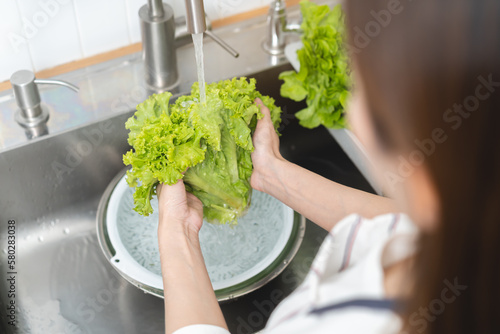 people washing raw vegetables at sink in the kitchen prepare ingredient for cooking photo