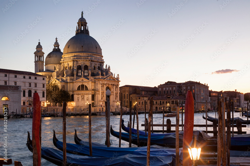 Venezia. Riva con gondole sul Canal Grande verso la Basilica di Santa Maria della Salute al crepuscolo.