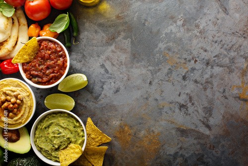 Fototapeta Homemade hummus, salsa and guacamole with corn chips
