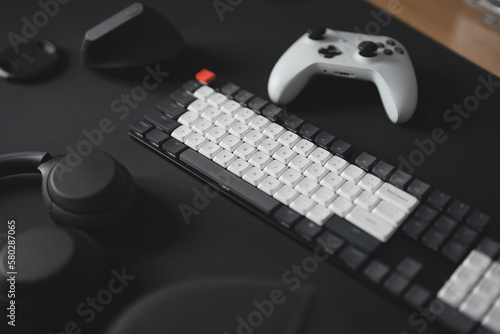 gamer work space concept, top view a gaming gear, mouse, keyboard, joystick, and headset on black table background.