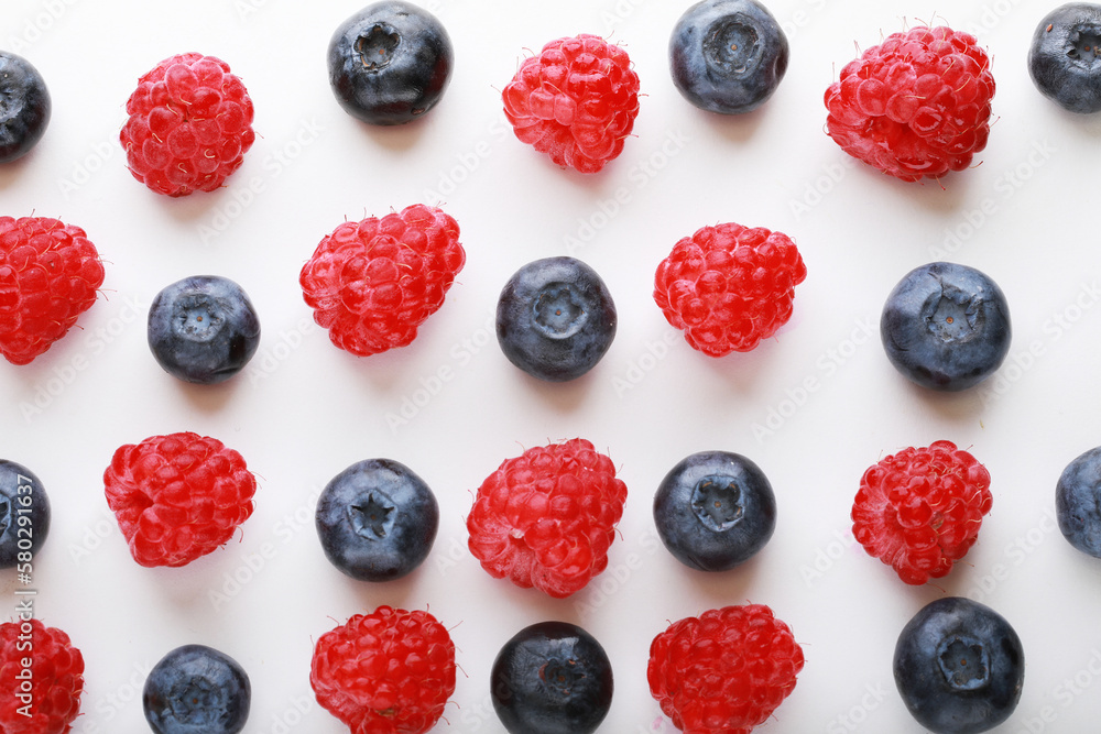 pattern of fresh blueberries and raspberries on a white background