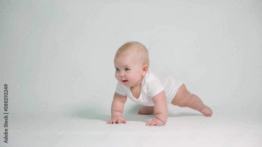 A little baby rises on his hands, learns to crawl . the concept of child development and health A little baby rises on his hands, learns to crawl . the concept of child development and health