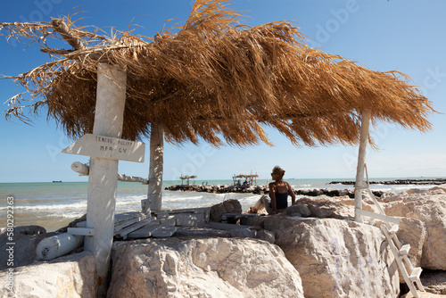 Lido di Venezia. Spiaggia dei Murazzi con gazebo di frasche e bagnante photo