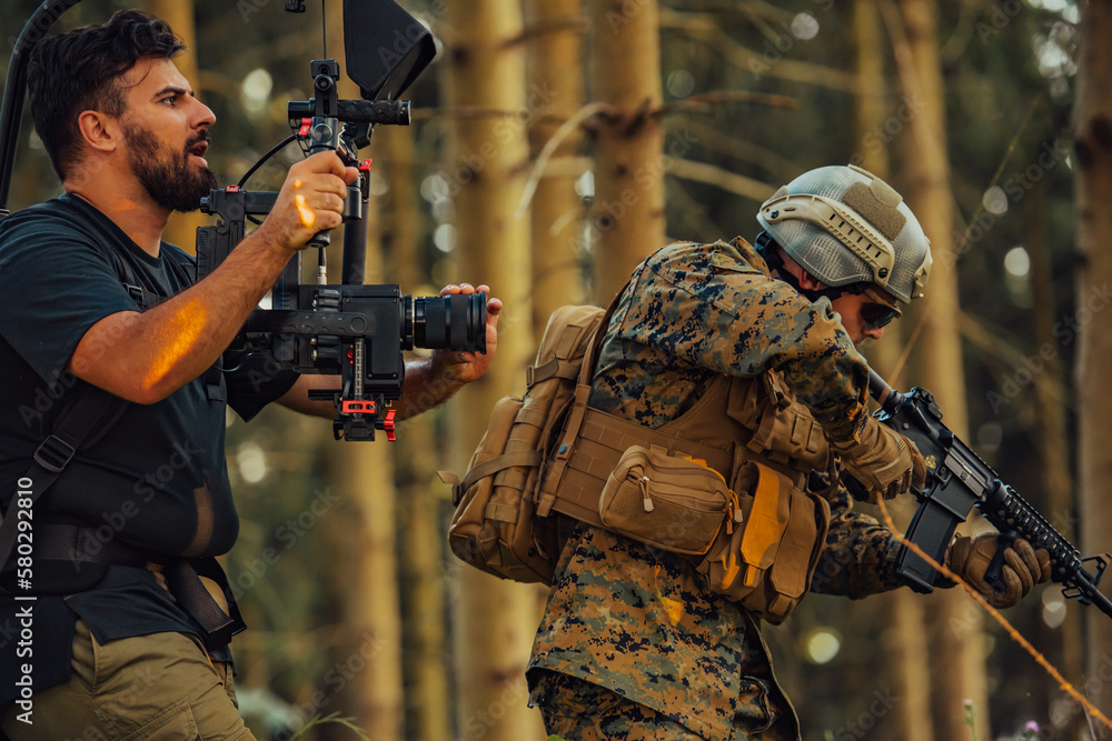 Fototapeta premium Videographer with Professional Movie Video Camera Gimbal Stabilizing Equipment Taking Action Shoot of Soldiers in Action in Forest