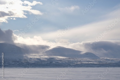 Beautiful scenery of snowy mountains in clouds. View from Lake Tornetr  sk  Tornestrask  around Abisko National Park  Abisko nationalpark . Sweden  Arctic Circle  Swedish Lapland