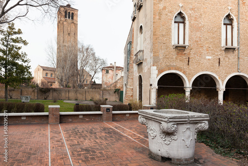 Murano, Venezia. Esterno del Museo del vetro con vera da pozzo verso il campanile della Cattedrale