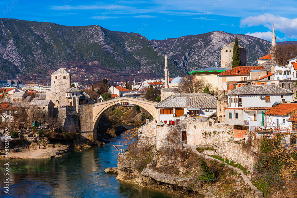 A bridge over the Neretva river with a mountain in the background, Mostar, Bosnia and Herzegovina