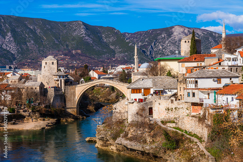 A bridge over the Neretva river with a mountain in the background, Mostar, Bosnia and Herzegovina
