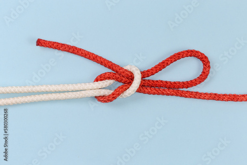 Rope Singly slipped reef knot on a blue background photo