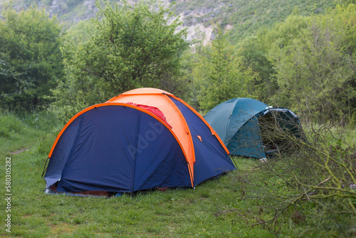 tourist tents in forest at campsite © Andrii