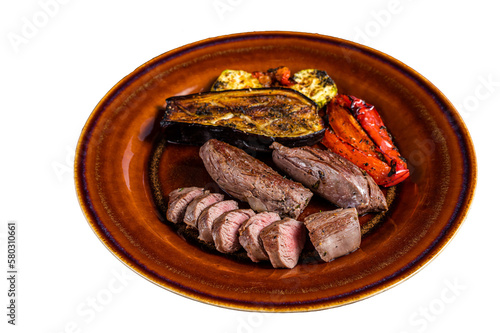 Grilled mutton tenderloin Fillet Meat, lamb sirloin on rustic plate with vegetables. Isolated, transparent background